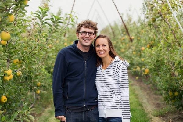 Man and woman at an apple orchard.