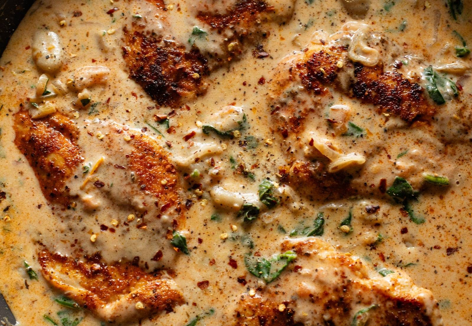 Finished chicken and gnocchi in a skillet.