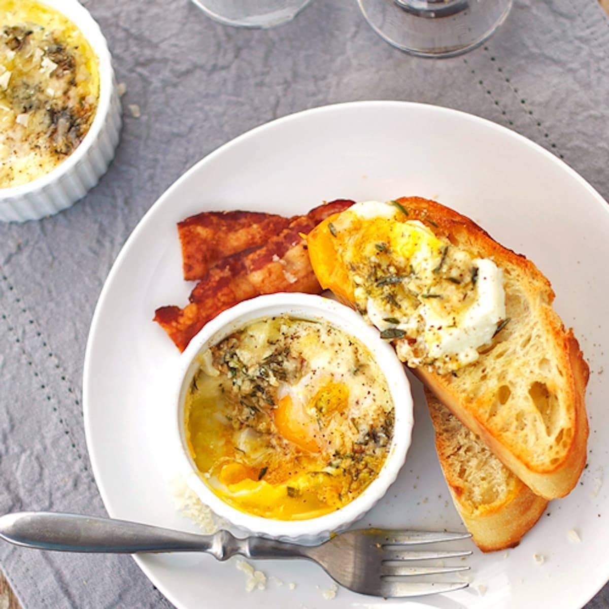 Parmesan baked eggs in a dish and on pieces of bread on a plate.